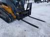 Stinger heavy-duty skid steer pallet forks transporting crates and supplies – built for power and long-lasting durability.