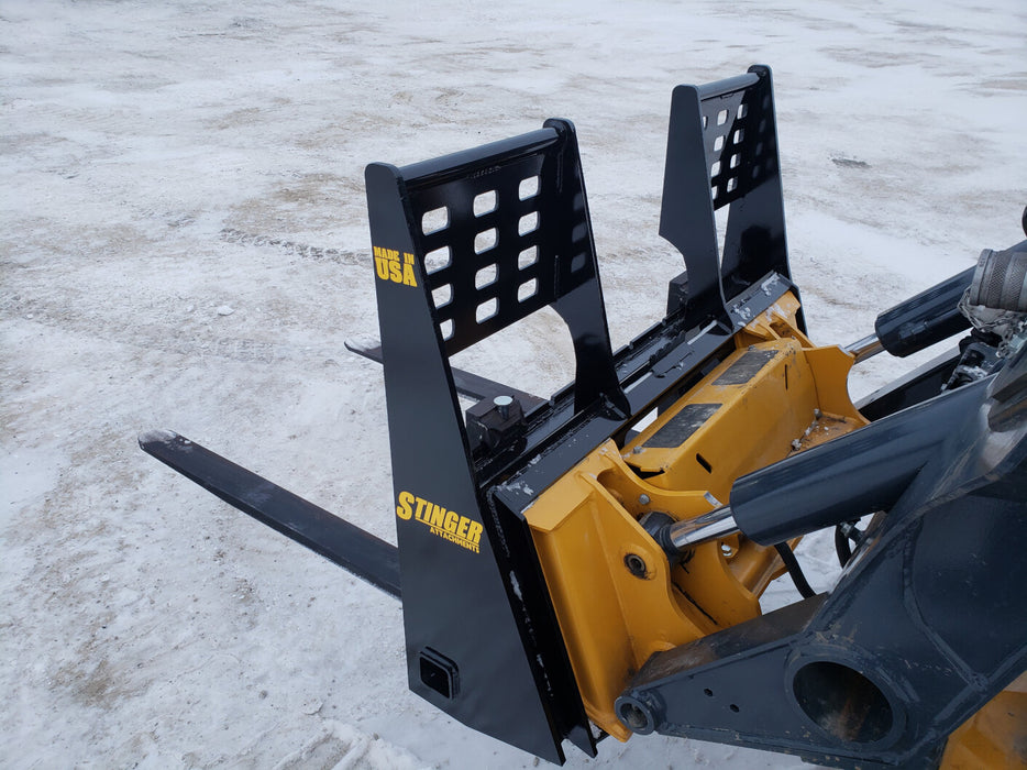 Side view of Stinger skid steer pallet forks mounted on loader – dependable attachment for precise material positioning.
