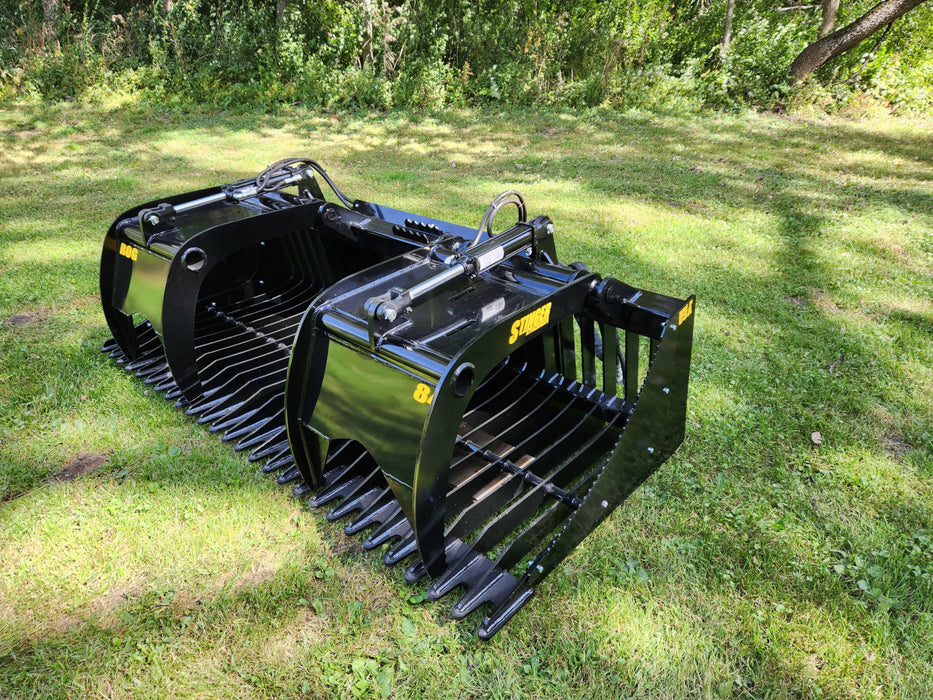 Heavy-duty skid steer grapple bucket by Stinger gripping stones – open-side design allows easy loading and unloading of materials.