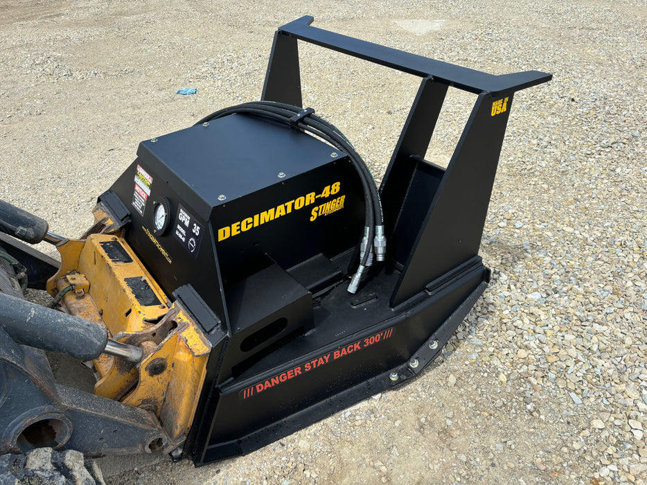 Operator controlling Stinger Decimator disc mulcher from skid steer cabin – high-efficiency cutting and mulching performance.