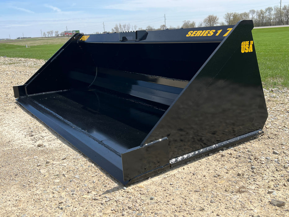 Stinger Series 1 skid steer material bucket grading terrain – heavy-duty attachment perfect for contractors and property owners.