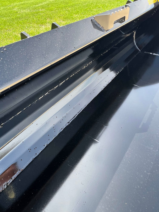 Heavy-duty skid steer material bucket by Stinger lifting soil pile – ideal attachment for excavation, leveling, and backfilling tasks.