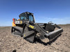 Skid steer rock reel attachment removing rocks from field – strong steel frame built for long-lasting use and heavy workloads.