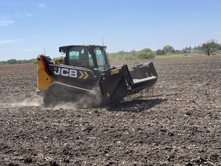 Durable skid steer rock reel attachment by Stinger separating dirt and stone – powerful solution for soil cleanup and maintenance.