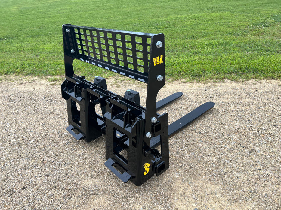 Heavy-duty skid steer pallet forks by Stinger moving large industrial loads – durable Class 3 design for high-capacity material transport.