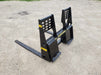 Heavy-duty skid steer pallet forks by Stinger lifting wooden pallet – durable attachment built for reliable material handling and transport.
