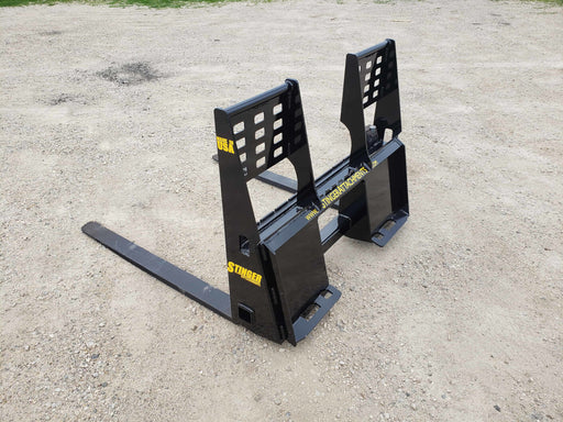 Heavy-duty skid steer pallet forks by Stinger lifting wooden pallet – durable attachment built for reliable material handling and transport.