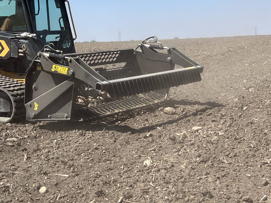 Close-up of Stinger skid steer rock reel attachment rolling debris – efficient screening design for fast and effective cleanup.