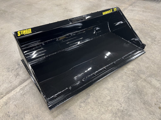 Stinger Series 2 skid steer material bucket loading gravel – heavy-duty attachment built for efficient material handling and construction work.