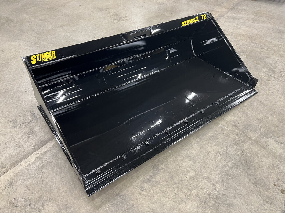 Stinger Series 2 skid steer material bucket loading gravel – heavy-duty attachment built for efficient material handling and construction work.