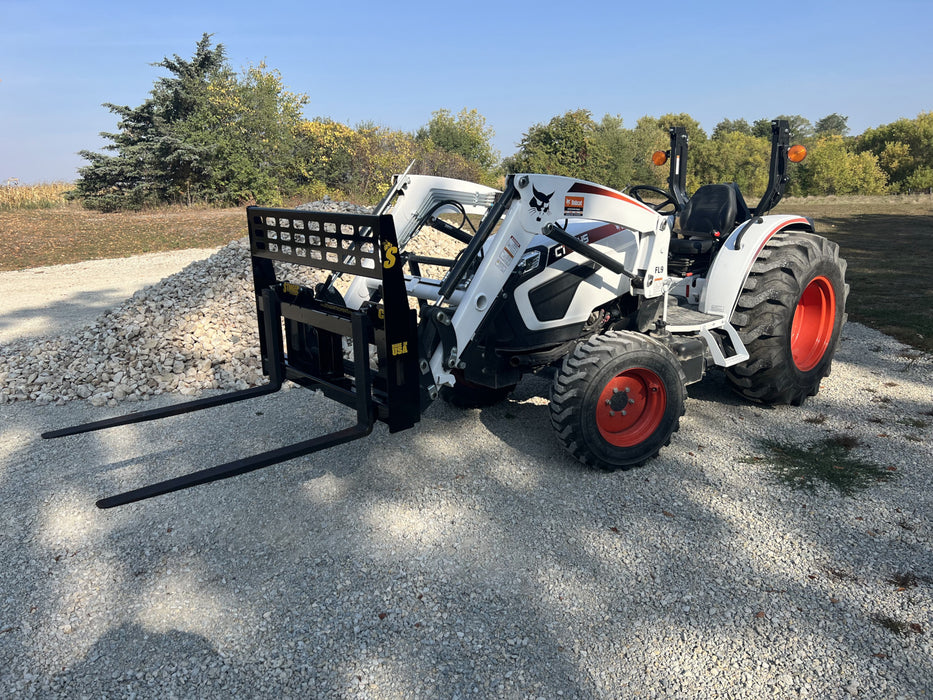 Heavy-duty skid steer pallet fork by Stinger lifting wooden pallet – durable attachment designed for efficient material handling and transport.