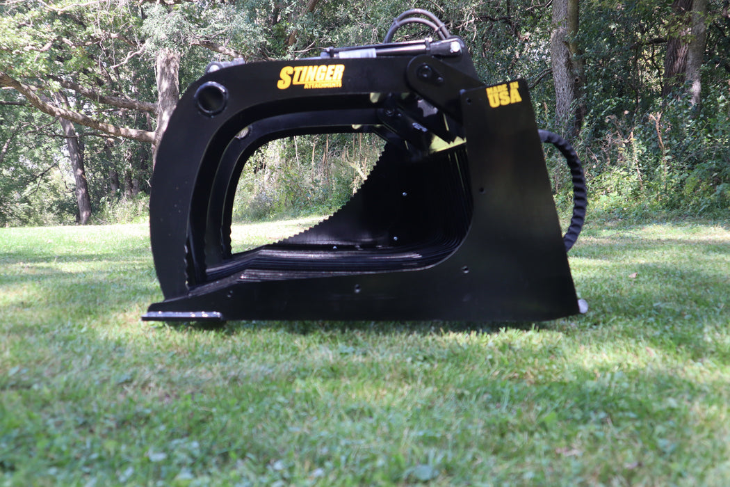 Stinger skid steer grapple bucket carrying mixed debris on jobsite – high-performance attachment for tough cleanup and grading tasks.