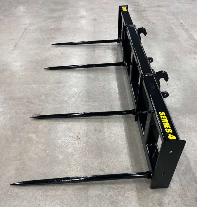 Dual-tine Stinger bale spear attached to tractor loader – perfect for moving large hay bales safely and efficiently on any terrain.