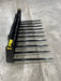 Heavy-duty skid steer grapple bucket by Stinger with manure spears gripping hay bales – durable and versatile attachment for agricultural use.