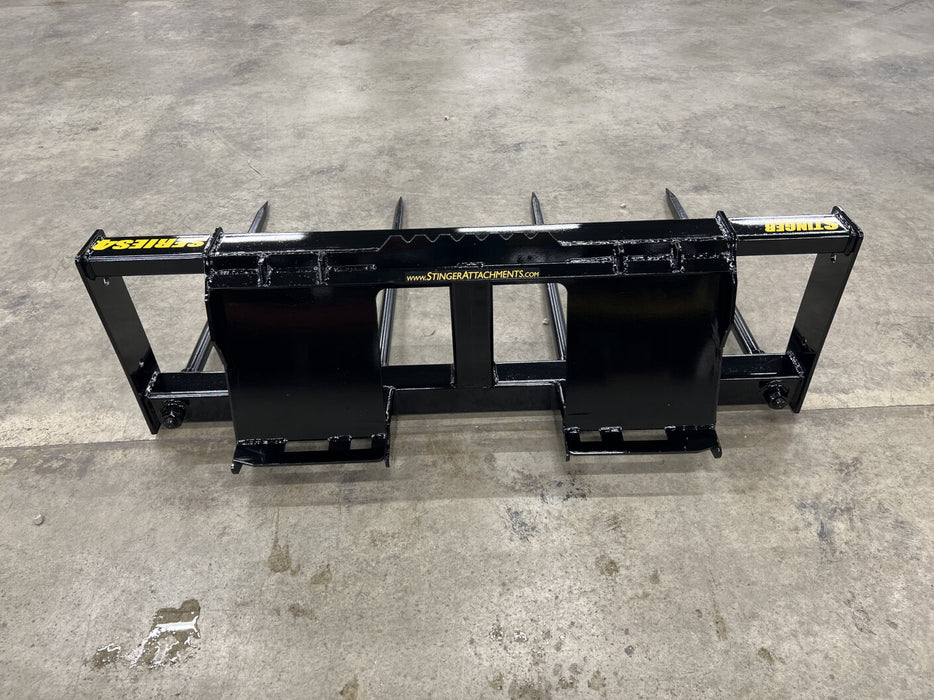 Farmer using a Bale Spear to transport a round hay bale across a barnyard during feeding season.