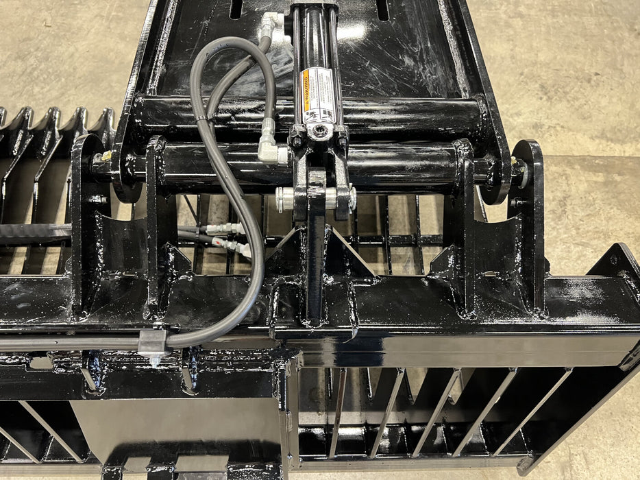 Heavy-duty skid steer rock bucket attached to loader sorting earth materials – professional-grade tool for site preparation and land maintenance.