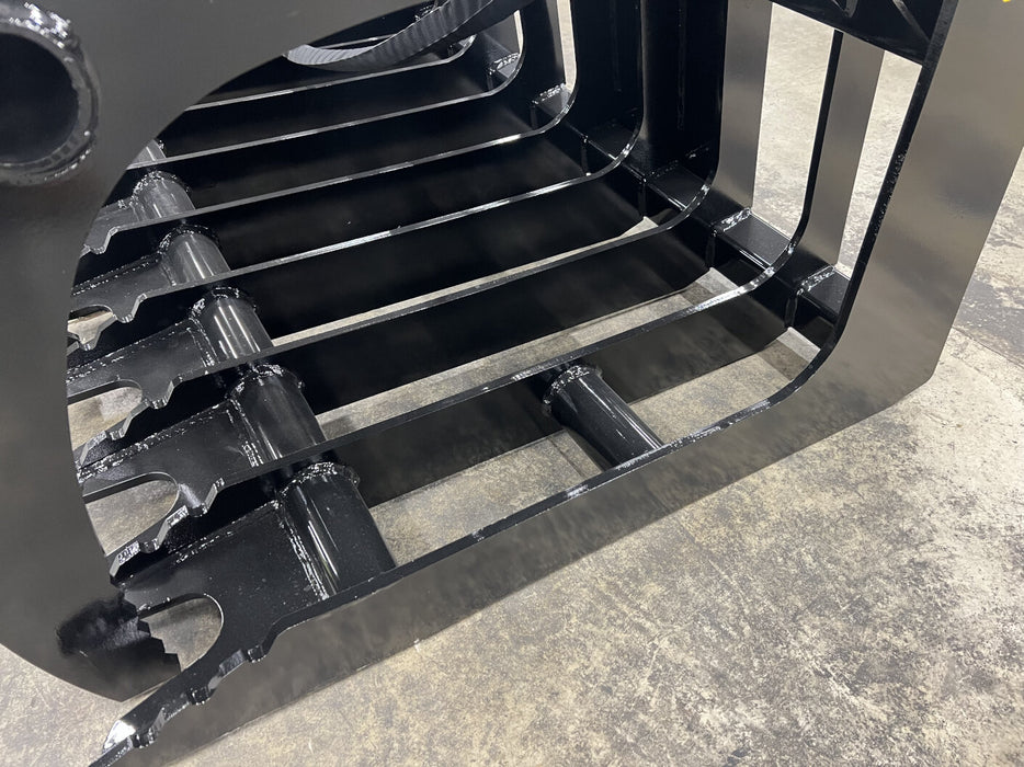 Utility tractor equipped with a tractor root grapple handling logs, stumps, and brush on a rugged job site.