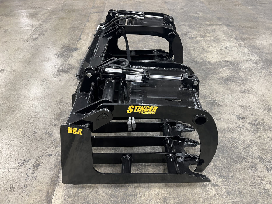 Rear angle of the tractor root grapple mounted on a front loader, showcasing easy quick-attach connection.