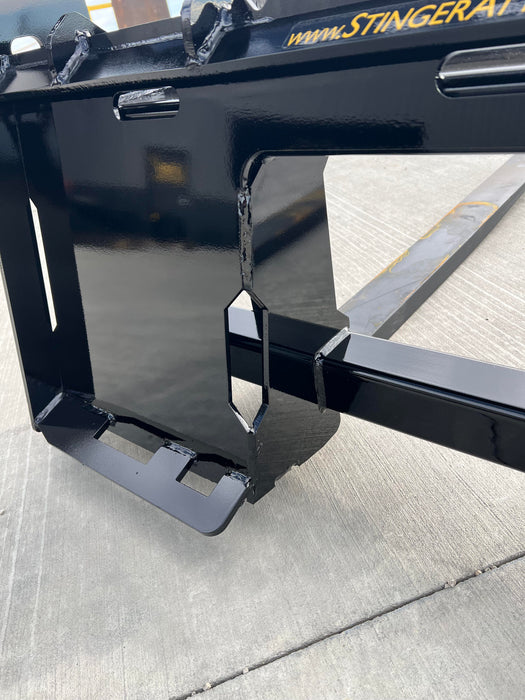 Side view of Stinger Class 2 skid steer pallet forks carrying crates – reliable attachment for farms, warehouses, and construction sites.