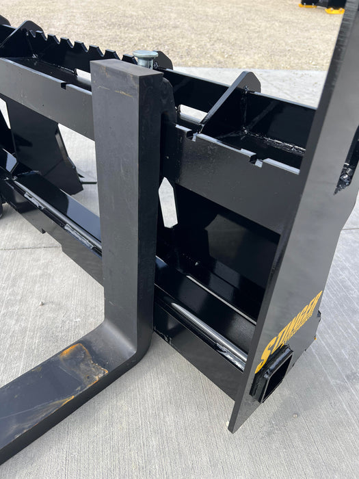 Stinger Class 2 skid steer pallet forks moving industrial pallets – heavy-duty, precision-engineered attachment for maximum efficiency and safety.