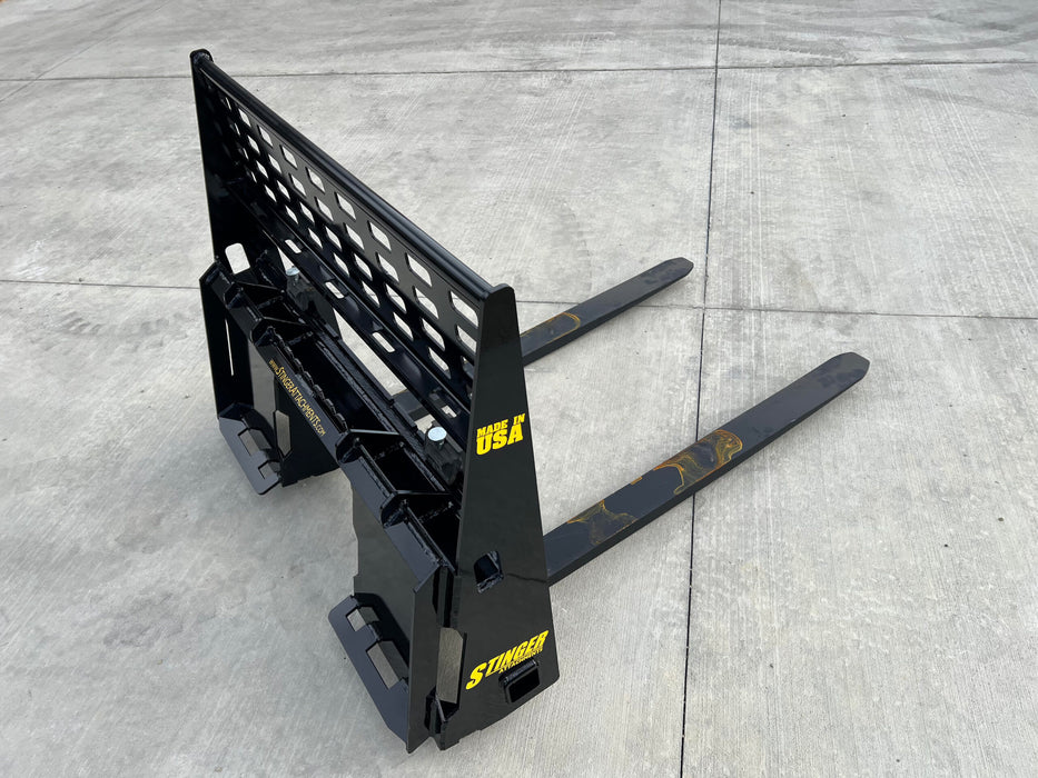 Operator using Stinger skid steer pallet forks to lift stacked materials – precision-built attachment for smooth and controlled operation.