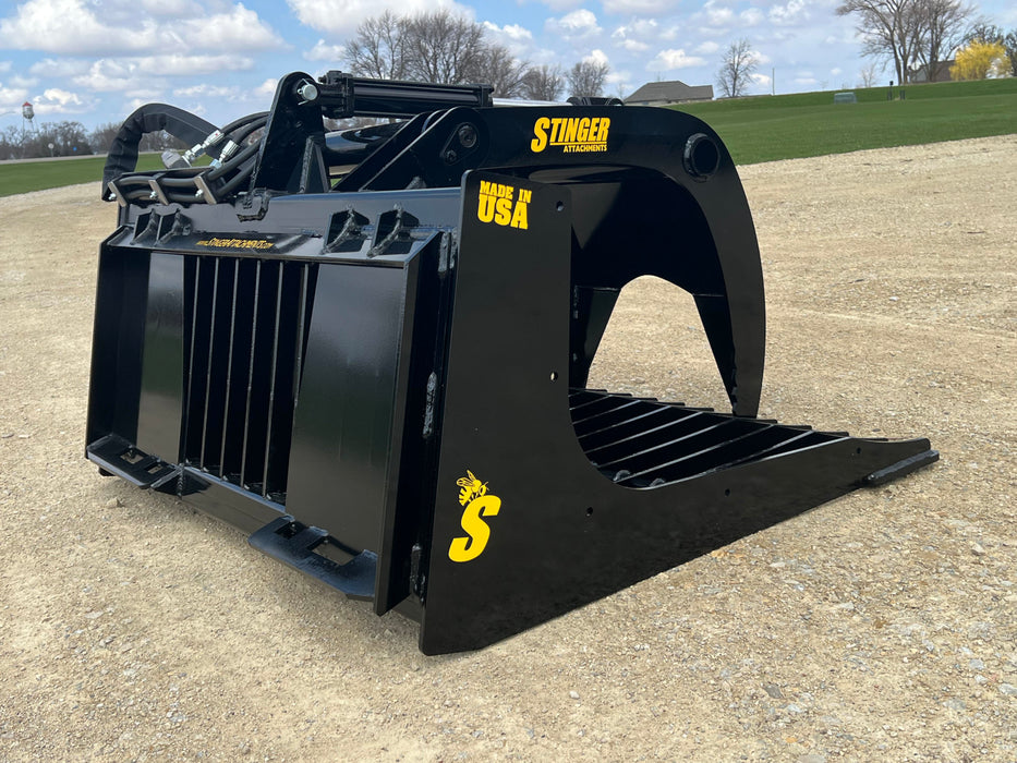 Heavy-duty skid steer grapple bucket by Stinger lifting mixed materials – strong and versatile tool for farms, construction sites, and property maintenance.