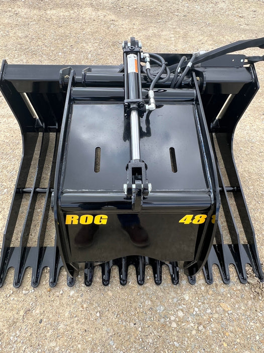 Durable skid steer grapple bucket clearing yard debris and stones – high-performance attachment built for tough working conditions.