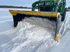 Compact skid steer snow pusher clearing heavy snow from driveway – durable attachment built for efficient winter maintenance.