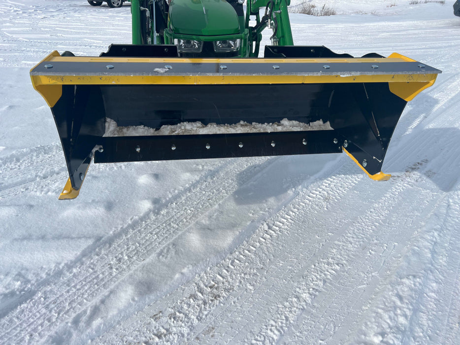 Side view of compact skid steer snow pusher handling deep snow – durable design provides maximum pushing efficiency and control.