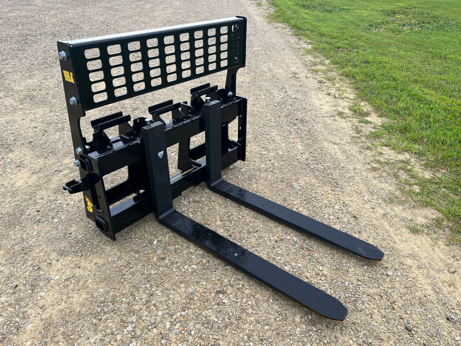 Front view of Stinger hydraulic skid steer pallet forks in action – robust attachment providing efficient material transport and precision lifting.