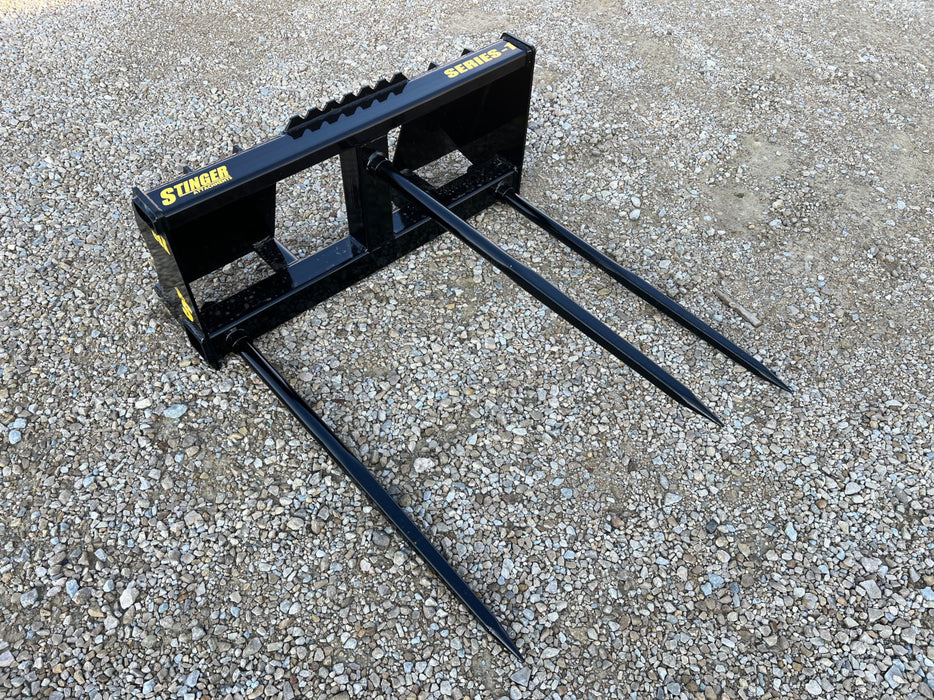 Stinger Attachments Series 1 bale spear lifting large round hay bale – durable standard-duty design for everyday farm and ranch work.