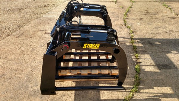 Operator using Stinger skid steer grapple bucket in barnyard – reliable attachment built for daily agricultural and livestock operations.